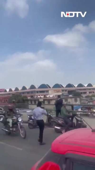 A man caused a traffic jam after throwing money on the busy streets of Bangalore.