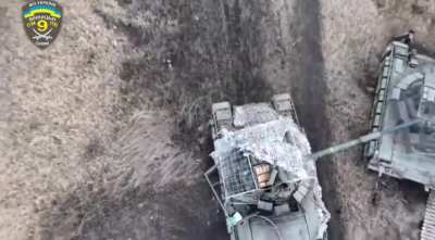 A Ukrainian drone pilot drops a grenade through the cope cage of a Russian T-80 BVM MBT into the open hatch, which destroys the tank and damages another close by. Neevelske, Donetsk Oblast