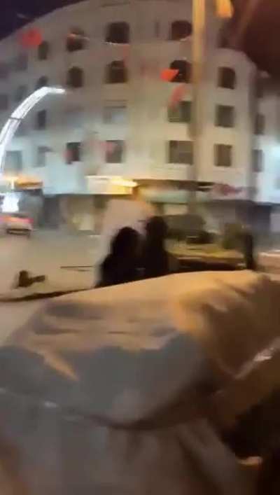 An Israel Defense Force soldier protecting a Palestinian women.
