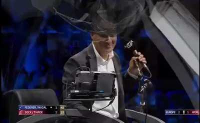 Federer hits passing shot between net and net post. "If he meant it we'll give it to him", McEnroe quips.