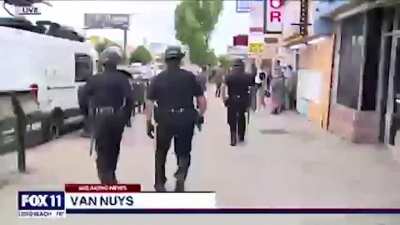 Police apprehend black store owners who are trying to stop white looters