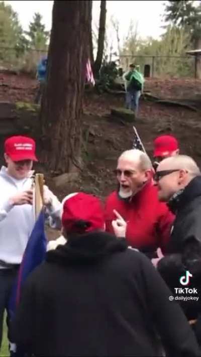 MAGAs surround a person flipping them off and proceed to lose their minds.