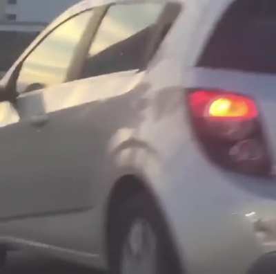 Woman twerks on roof of a car while the car is driving on a Miami highway
