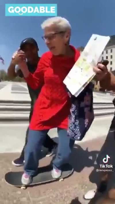 Two young skateboarders were walking along the street when they saw elderly woman watching them. She had never skateboarded before. When they found out, they knew what to do. They made her dream come true.