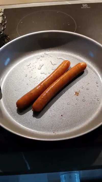Sausages rolling themselves on the pan.