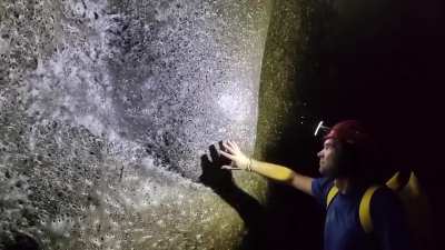 Man touches the world's largest spiderweb, covering 106 m&sup2; in a sulfur cave on the Albania-Greece border