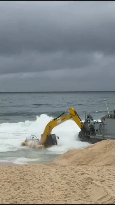 Escavadeira foi tentar desencalhar o navio da Marinha e tb ficou encalhada na praia da macumba