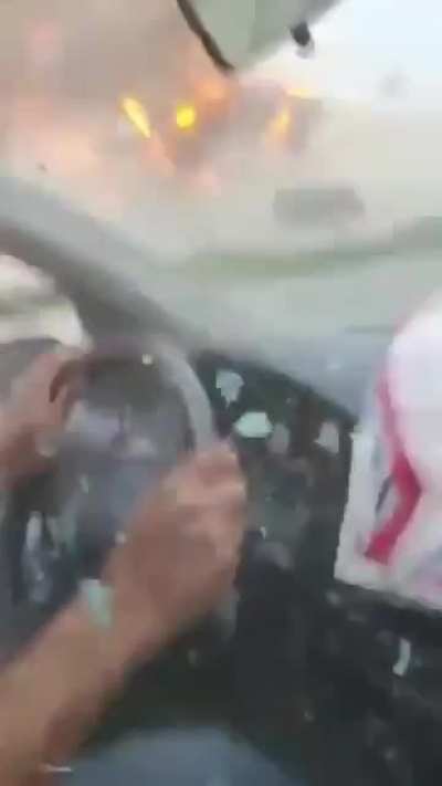 A civilian in a car captures one of the U.S.-Israeli strikes to the energy and water infrastructure in Bushehr, Iran