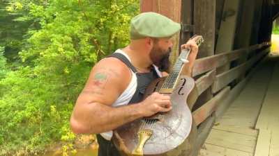 Playing slide guitar with a spoon in my mouth while fingerpicking on my old National Guitar.