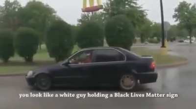 Holding a BLM sign.