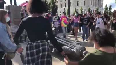 Historic moment in Minnesota as Native Americans, allies, & a cute doggo dance around the fallen statue of Christopher Columbus