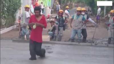 Man walks on a cement road which is being made