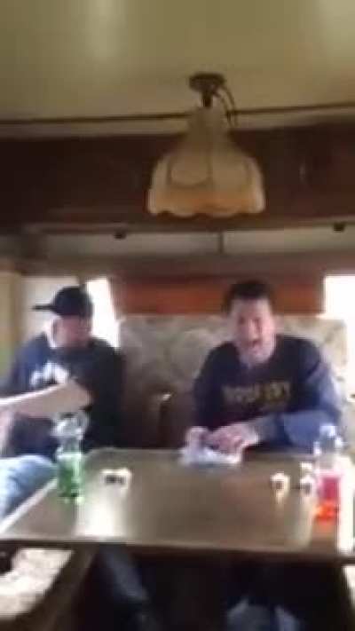 Two people trying to eat Surstr&ouml;mming (fermented fish!), A typical swedish dish. It is said that the smell is so strong that the recommendation is to open the can outside the house, inside a bucket full of water.