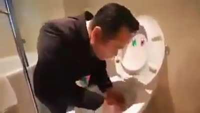 This man trying to proof how clean is his hotel's toilet