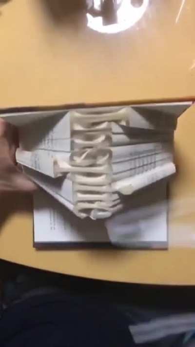 Folding book pages to spell "inspire"