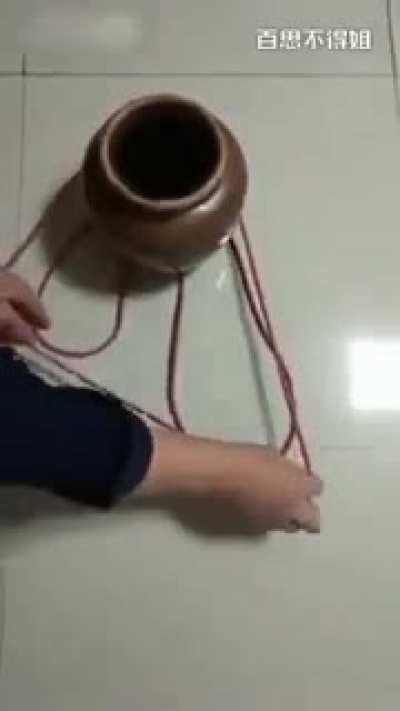 Using a single piece of string to securely carry a clay pot