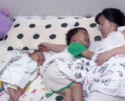 He wanted to cuddle his mum and wasn't going to let his baby sibling stop him. 