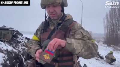 Ukrainian soldier shows off captured Russian badges