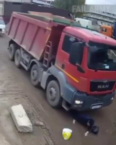 Woman ignores surroundings; truck ignores her existence.