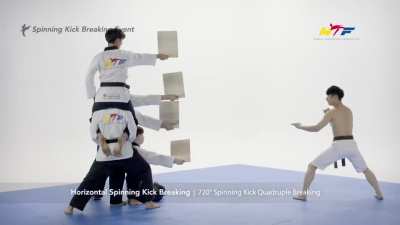 Spinning quadruple kick breaking all boards in one go.