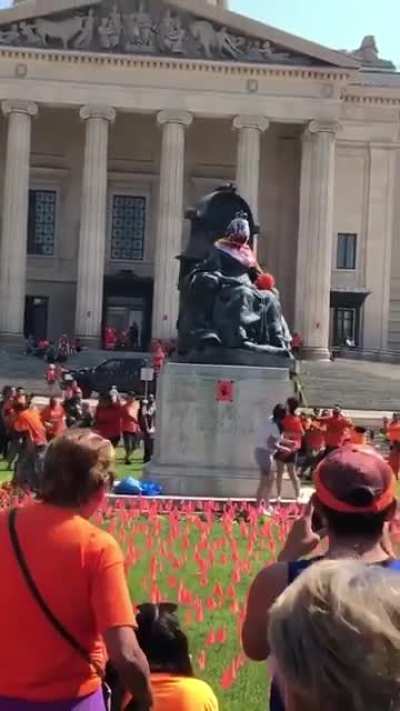 Demonstrators toppled statues of Queen Victoria and Queen Elizabeth in Winnipeg this afternoon during rallies honouring the children discovered in unmarked graves on the sites of former residential schools over the past month [different angle].