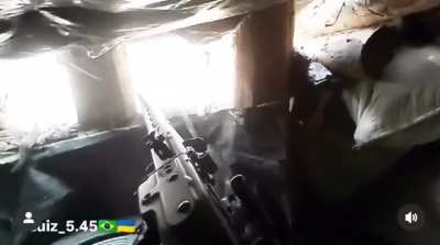 Brazilian volunteer Luiz providing medical assistance and holding his position with grenade launchers and an LMG