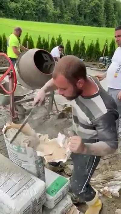 Putting cement in the concrete mixer.