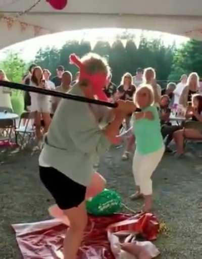 Old Lady walking in front of a pinata