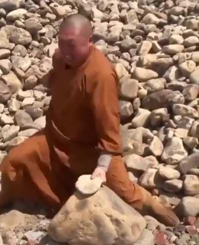 Monk brakes stones with his hands/fingers