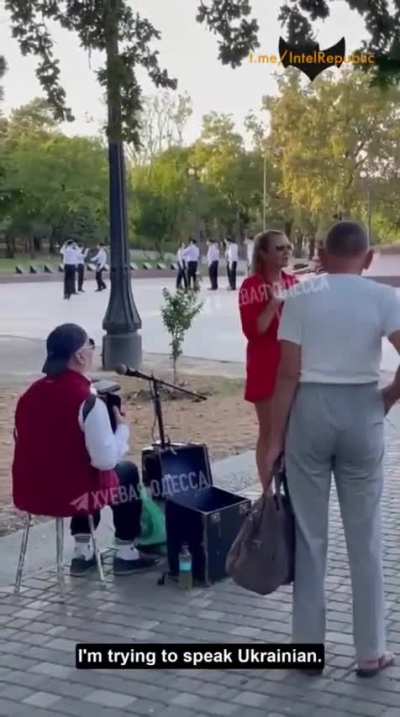 Woman tries to stop a street singer from singing in Russian in Odessa, Ukraine