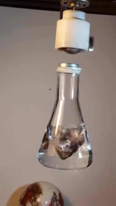 Motor speed ~3600 RPM (60 rev/s) matches the camera frame rate, freezing both the rotation and the flask&rsquo;s oscillation, revealing their synchronization in real time. A magnet trapped in air by a rotating dipole field.