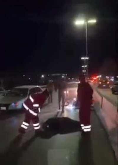 While news reporter is on a live stream reporting a car accident, a guy on a motorcycle crashes into that car on the road.