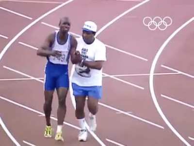 Dad rushes on to track to help son finish races after the son tears his hamstring at the Olympics.