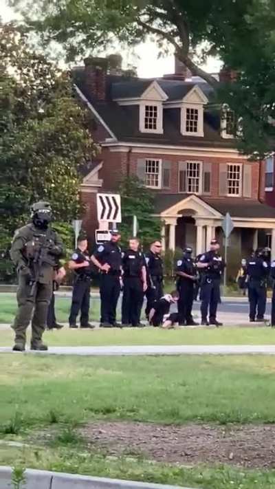 Police officer in Richmond, VA spits on and near a detained protester multiple times, during a pandemic.