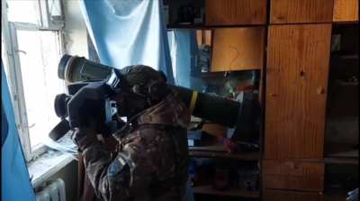 A Ukrainian soldier fires from a Javelin indoors.