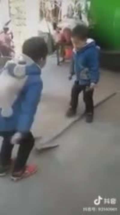 Two kids playing with a shovel