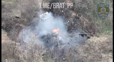 Ua POV A camouflaged Russian Grad launcher with trash on top is set on fire by a Ukrainian drone. Russian troops try to put it out and a fire truck shows up.