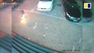 Child putting a lit sparkler down a manhole