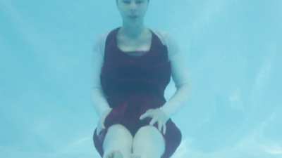 Cute girl blows beautiful bubbles underwater.