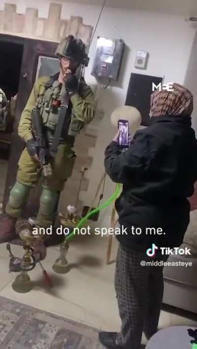 Palestinian women smokes shisha as Apartheid soldiers raid her house.