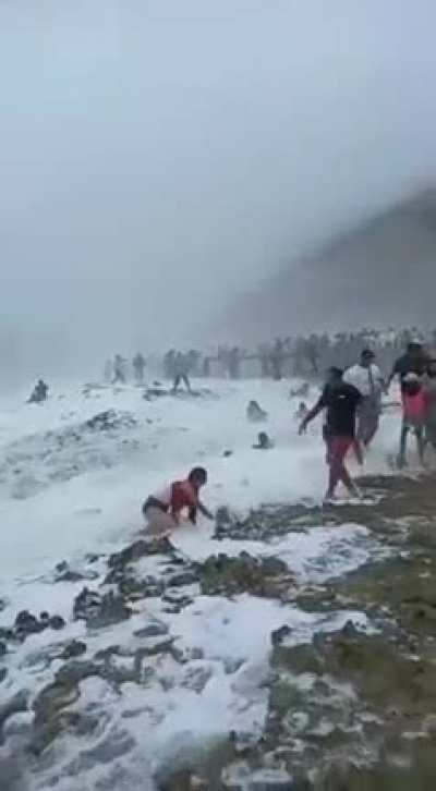 Tourists cross fence around sea cliff. Mother Nature drags them out to sea.
