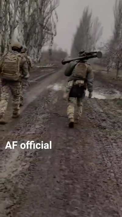 Ukrainian troops march along a muddy road with FIM-92 Stinger MANPADS at the ready.