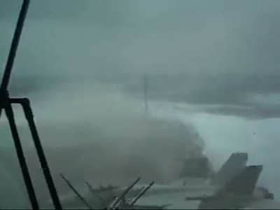 A Rhino and a Seahawk sit peacefully on the deck of USS Kitty Hawk (CV-63) in a stormy weather. [Video]