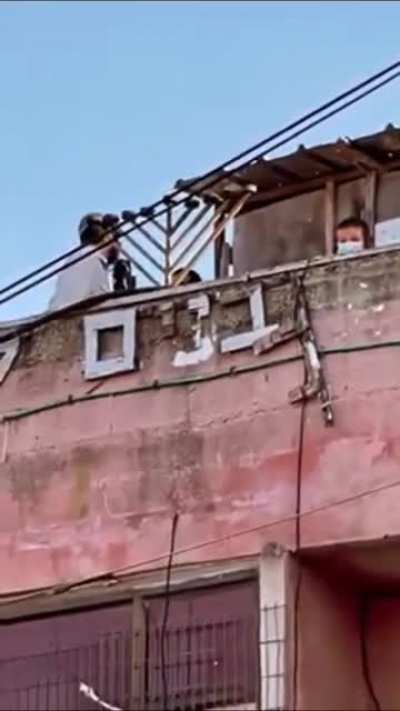 A Woman in Sheikh Jarrah neighborhood, was kicked out of her house forcedly, while zionists enjoy their time on the roof of her house &amp;amp; her standing outside at the doorstep not allowed to enter