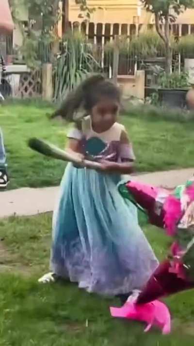 A girl swinging a bat at a pi&ntilde;ata
