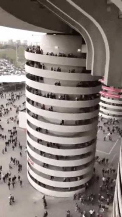 It looks like the whole column is turning but in fact only the people do. The reason for this is that you can't see the moving legs, so the people appear to be standing.