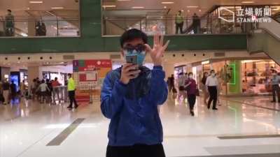 In defiance of the national security law, lunchtime protest regular "David" sings a numeric version of the protest anthem "Glory to Hong Kong" whilst holding fingers to symbolise "5 demands not 1 less", doing it all by himself. [Stand News]