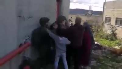 A palestainian family tries to stop Israeli soldiers from kidnapping their child