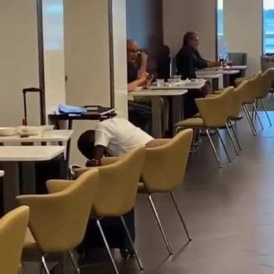 Possibly senile old man shaving in airport lounge, to the horror of actor Michael Rappaport