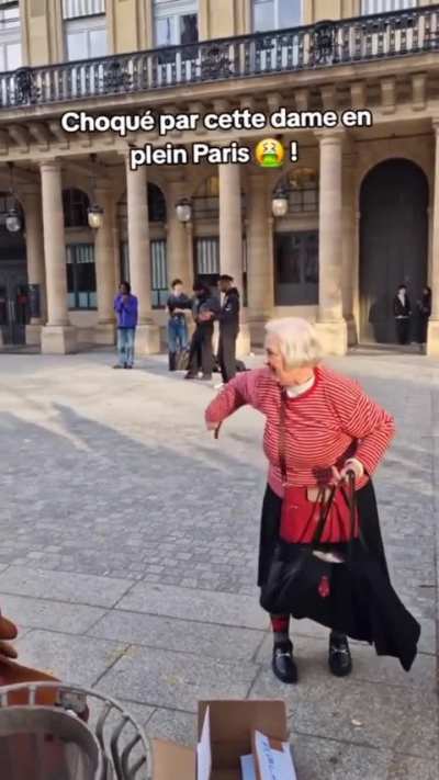 Old French lady making monkey gestures at a group of black guys